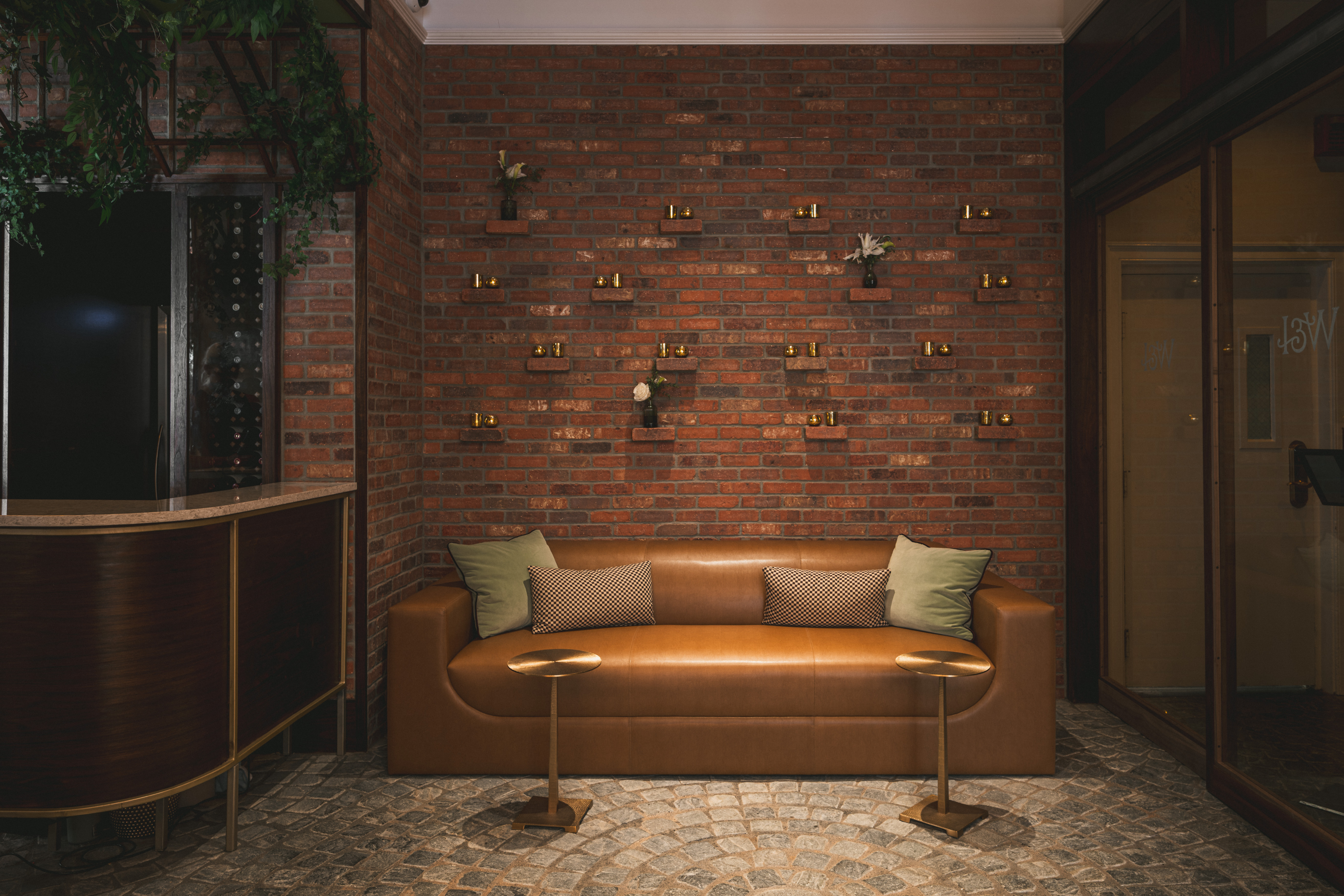 Backlit banquette seating against an exposed brick wall